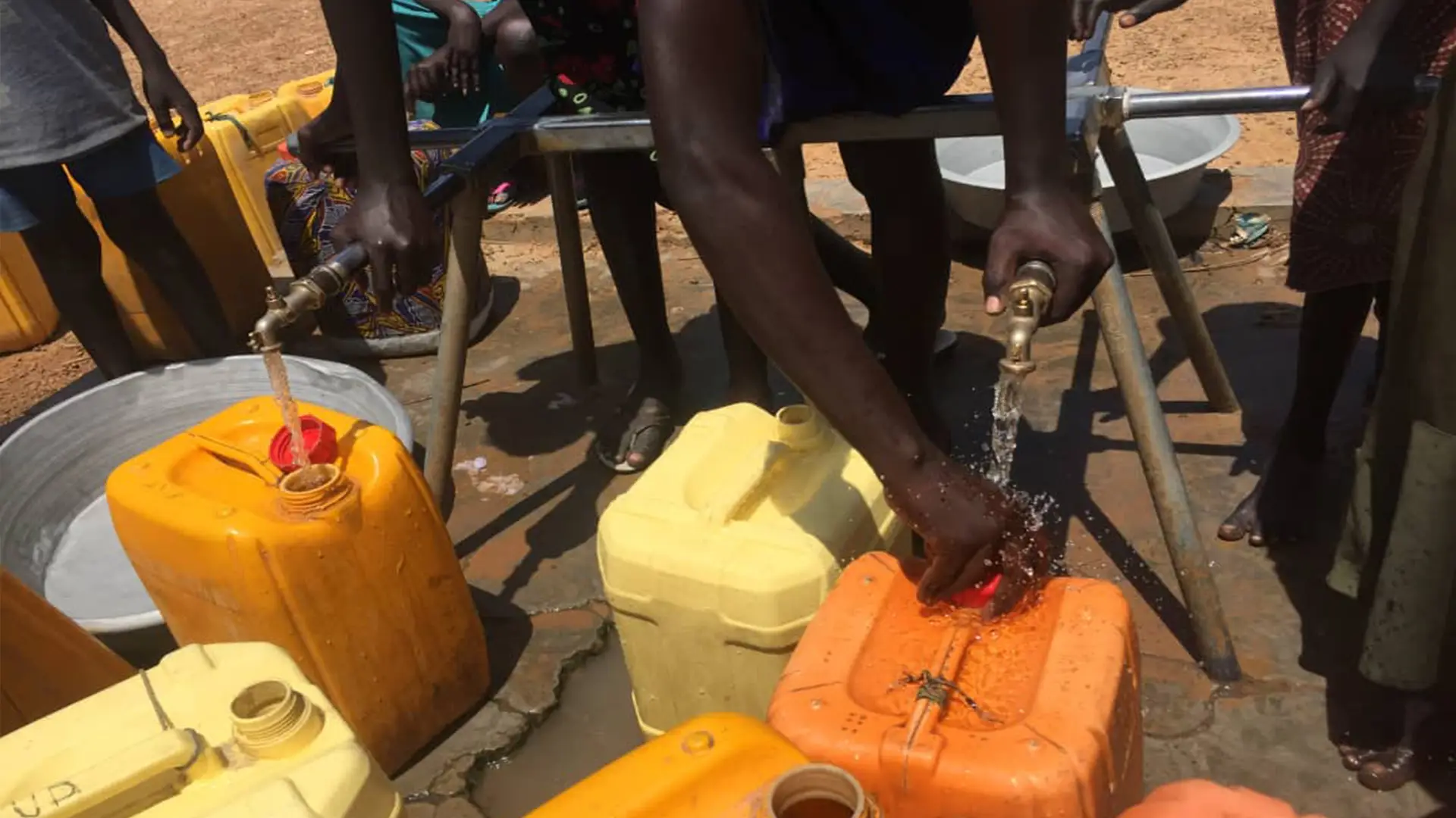 Residents filling jerrycans from a multi-tap water point in Lakes State