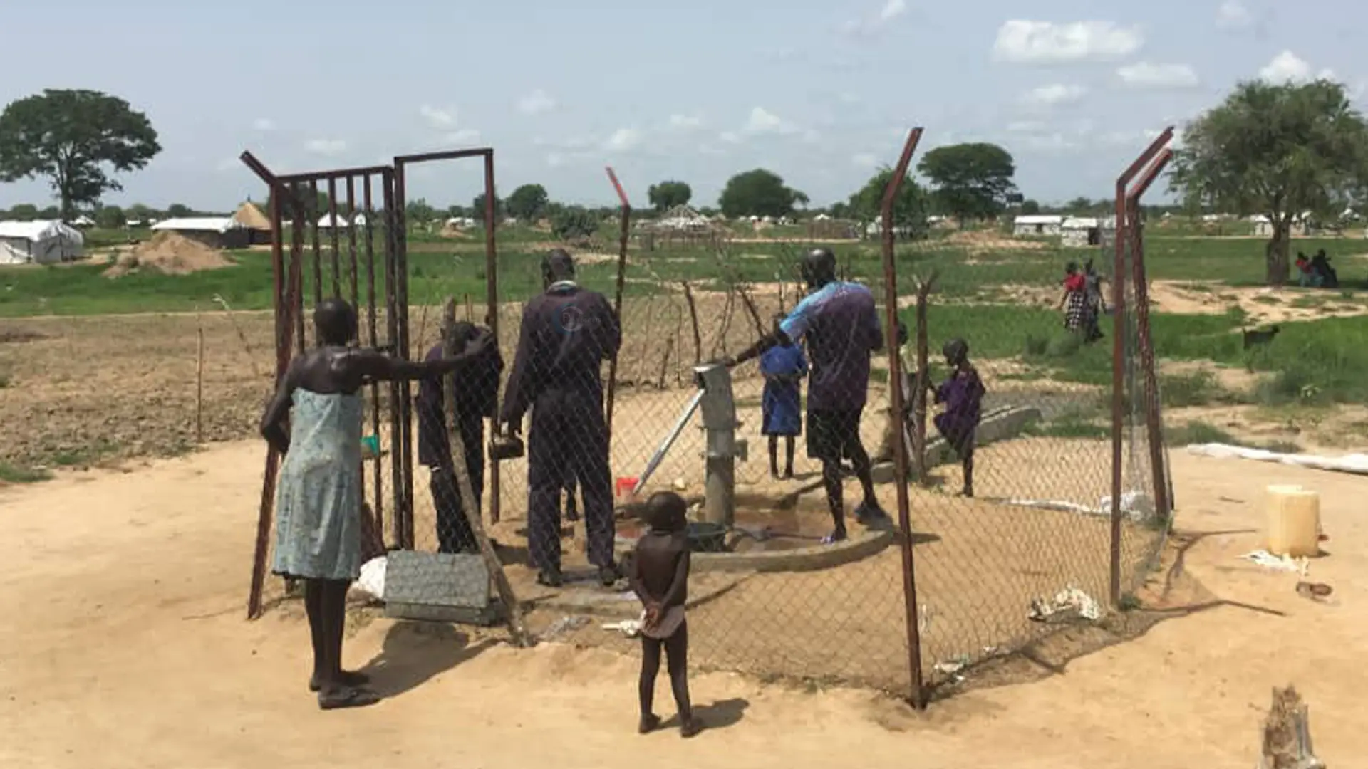 Community members using a fenced handpump water point in Lakes State